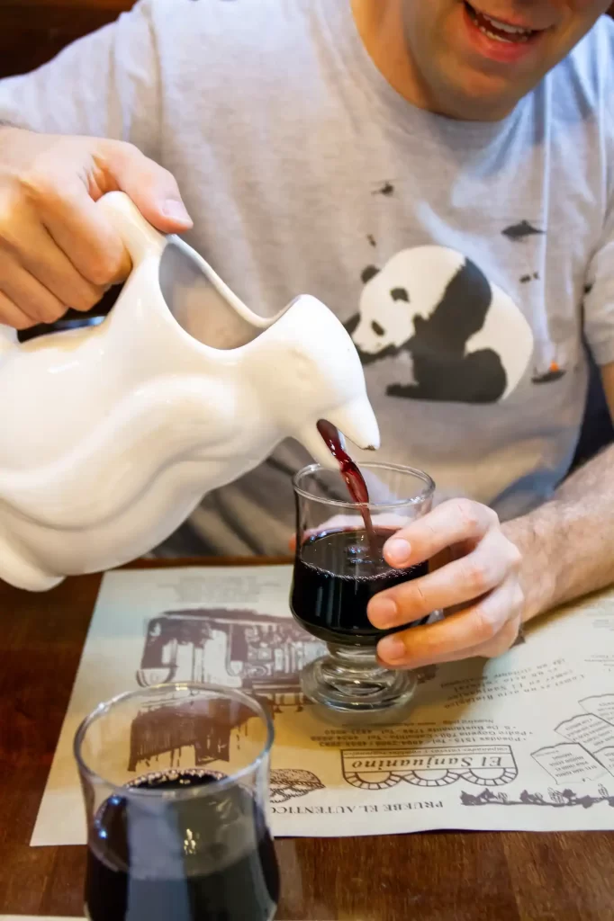 Pouring Wine from Pinguine Carafe at El Sanjuanino 