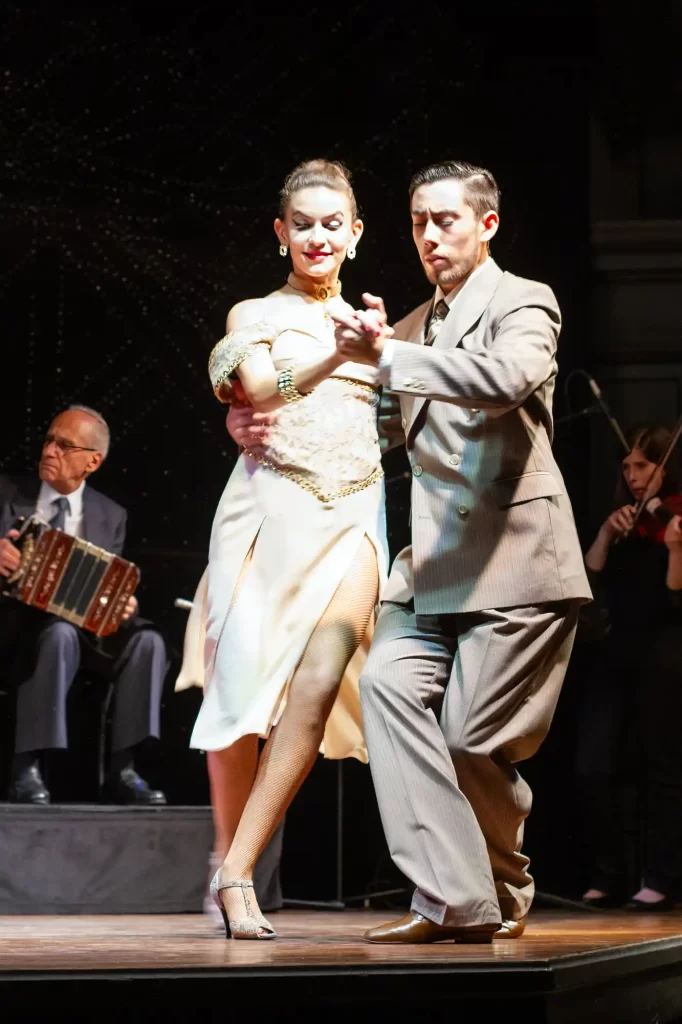 Couple dancing Tango on Stage in Buenos in beige dress and suit